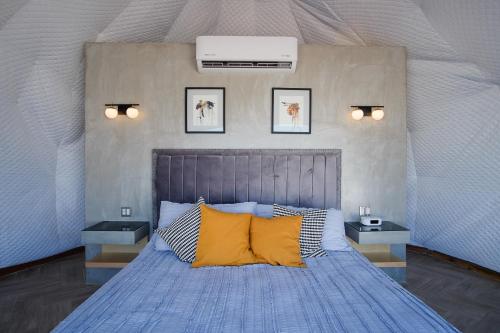 恩塞纳达港Cúpulas Del Valle by Villa De La Rosa的一间卧室配有蓝色的床和黄色枕头