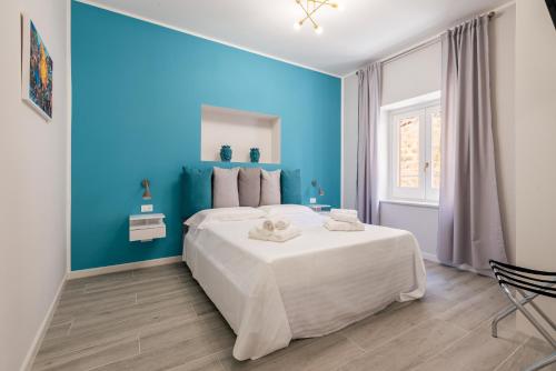 巴勒莫LE PORTE DEL KASSARO的蓝色的卧室设有白色的床和蓝色的墙壁