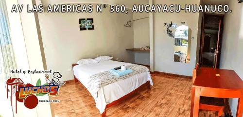 AucayacuHOTEL LUCHO'S的一间卧室配有一张床和一张桌子