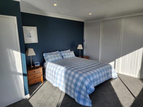 但尼丁253 on HIGHGATE的一间卧室设有一张床和蓝色的墙壁