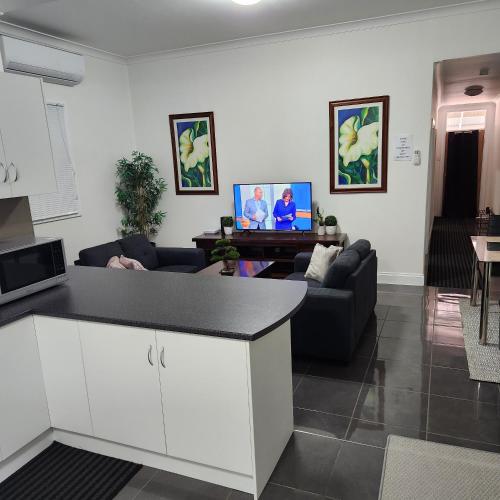 布罗肯希尔City Villa 39 Blende st Broken Hill NSW 2880的厨房以及带沙发和桌子的客厅。
