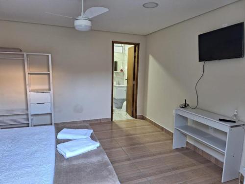阿瓜斯迪林多亚Pousada Saint James的客房设有电视和带毛巾的床。