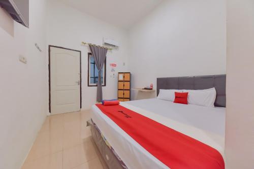 打拉根Reddoorz near Juwata Airport Tarakan的卧室配有一张大白色的红色床单