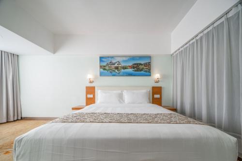 深圳深圳山水时尚酒店华强北店的卧室配有一张白色大床