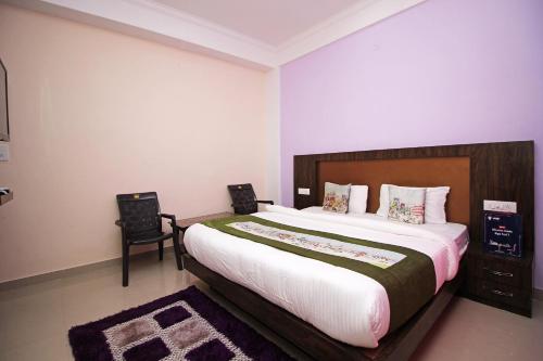 达兰萨拉OYO Hotel Chandni的一间卧室配有一张大床和两把椅子
