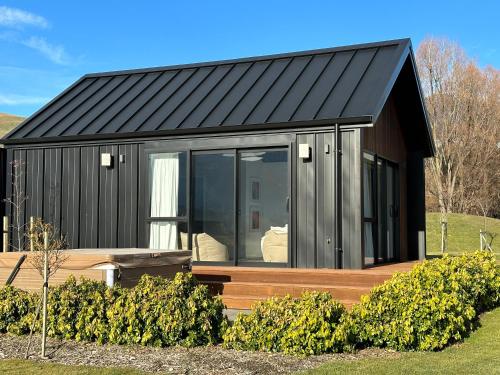 弗兰克顿Guest House with a Stunning View的一座带黑色屋顶和木甲板的房子