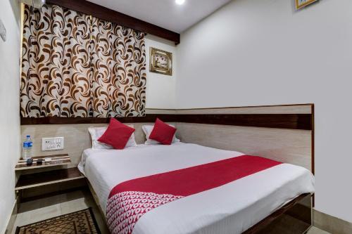 贾姆谢德布尔OYO Hotel Satguru的一间卧室配有一张带红白毯子的床