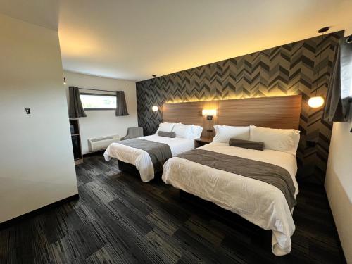 Little CurrentManitoulin Motel的酒店客房带两张床和一个大床头板