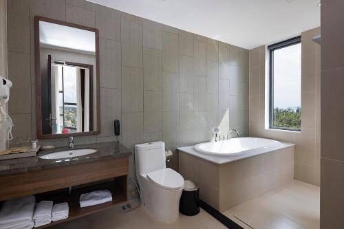 后川Le Palmier Ho Tram Resort的一间带水槽、浴缸和卫生间的浴室