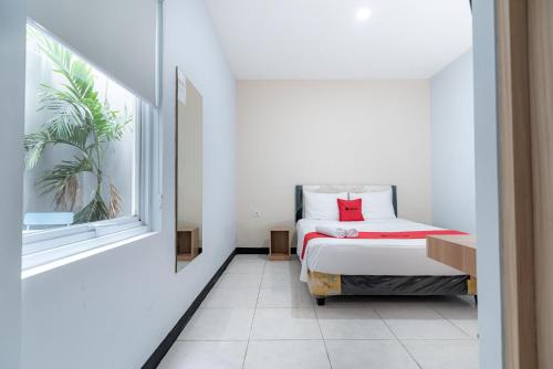 雅加达RedDoorz near Puri Indah Lippo Mall 2的一间小卧室,配有床和窗户