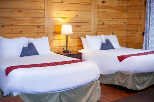 TerrebonneCrooked River Ranch Cabins的木墙客房的两张床