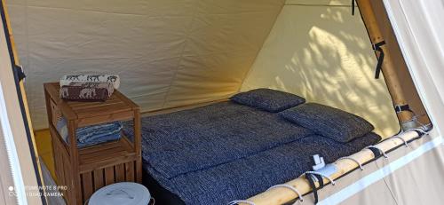 GradacNa vrtu K25的一张小床,位于带桌子的帐篷内
