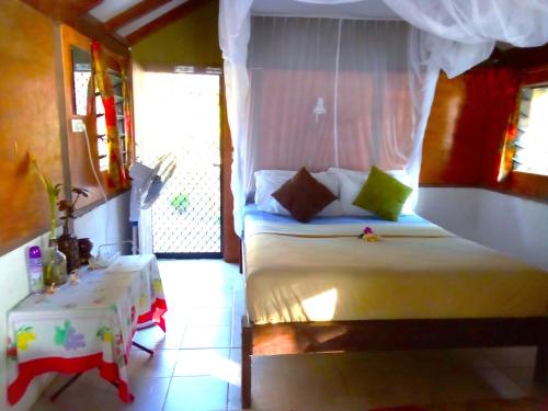 维拉港Vatupau Beachfront Bungalows的卧室配有白色的床和桌子