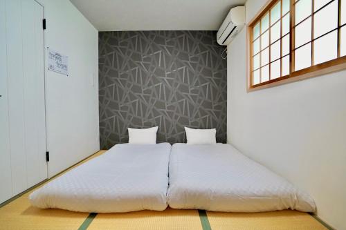 京都Haku Tofukuji的卧室配有白色的床和2个枕头