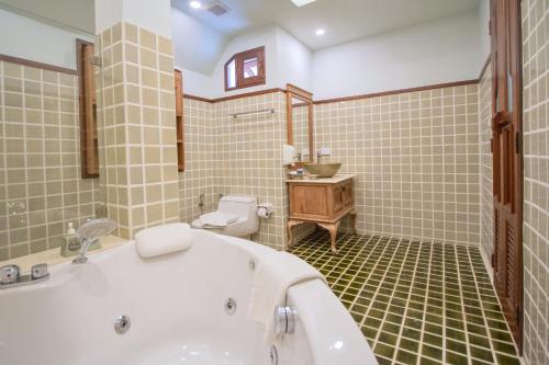 清迈富园之家酒店的带浴缸、卫生间和盥洗盆的浴室