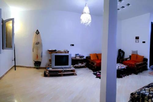 塔哈佐特Artic House的一间带电视和冲浪板的客厅