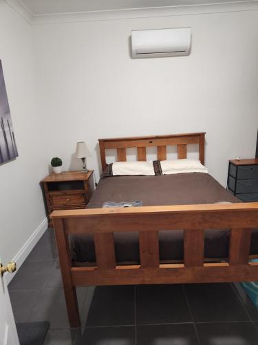 布罗肯希尔City Villa 41 Blende st Broken Hill NSW 2880的一间卧室配有木床和床头柜