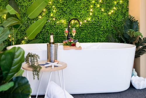 埃尔利海滩Bella Paradiso的绿色墙壁前的浴缸,带灯
