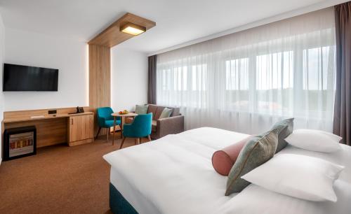 久洛Hunguest Hotel Gyula的一间酒店客房,配有一张床和一台电视