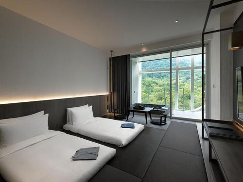礁溪风华渡假酒店-礁溪馆的一间卧室设有两张床和大窗户