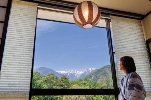 驹根市山吹旅馆的一位从窗户望向山间的女人