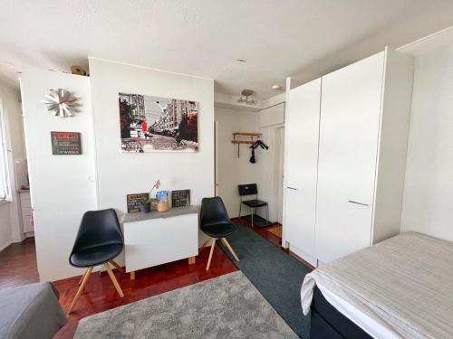赫尔辛基Sweethome Studio 48 City Center Аlbertinkatu的一间卧室配有一张床、一张桌子和两把椅子