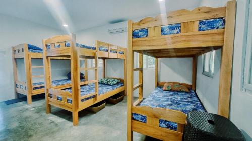 圣胡安Beach House, San Juan, La Union的一间卧室配有三张双层床。