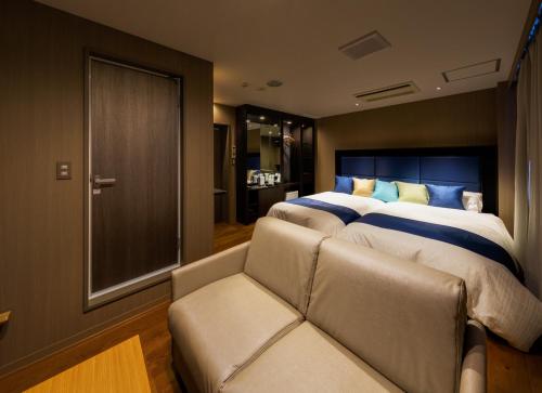 富士吉田市Hotel Fuji Tatsugaoka的一间卧室配有一张大床和一张沙发
