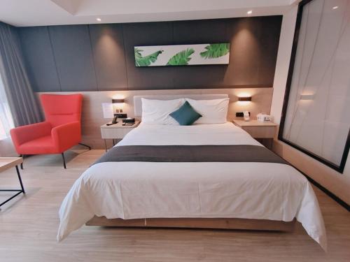 绵阳尚客优品绵阳师范学院酒店的一间卧室配有一张大床和一张红色椅子