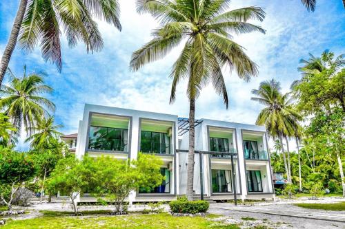 塔林甘海滩Am Samui Resort Taling Ngam的一座棕榈树建筑