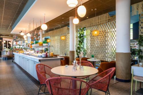 奥利巴黎核心奥利机场宜必思酒店的一间带红色桌椅和柜台的餐厅