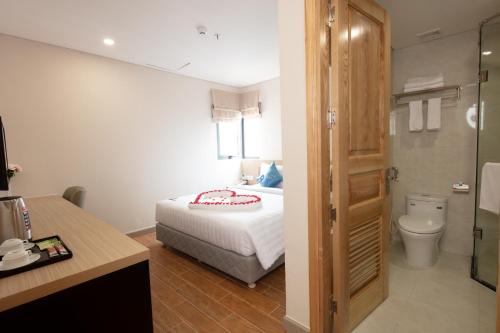 芽庄Elite Hotel Nha Trang的一间卧室配有一张床,浴室设有卫生间
