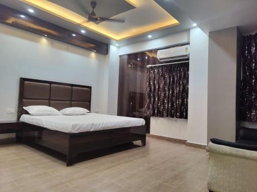 瓦拉纳西Surya Niwesh 103的一间带一张床铺的卧室,位于带天花板的房间内