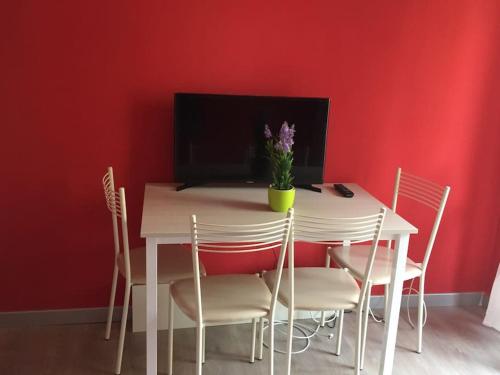 科帕内罗Trilocale IMMinens mari的一张餐桌和椅子,墙上是红色的墙