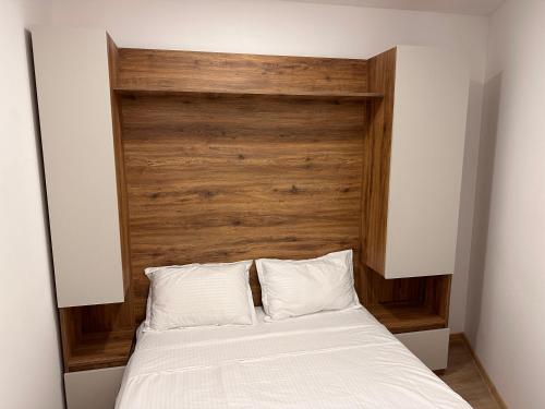 马钦加里Aparthotel costa的一张带木制床头板和两个白色枕头的床