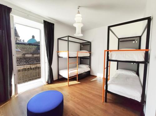 那不勒斯Tric Trac Hostel的客房设有三张双层床和一扇窗户。