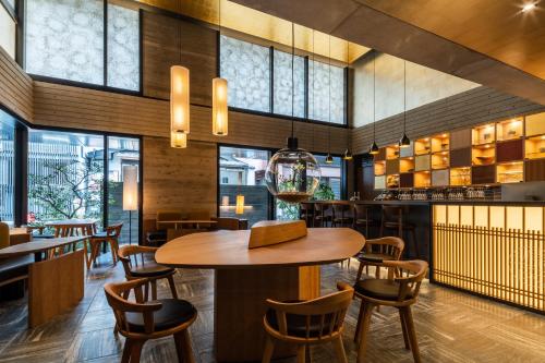 京都Genji Kyoto, a Member of Design Hotels的餐厅配有木桌和椅子