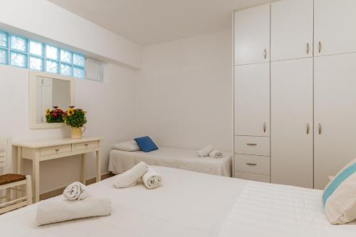 法蒂亚Afroditi Ftelia Yasemi b的一间白色卧室,配有两张床和镜子