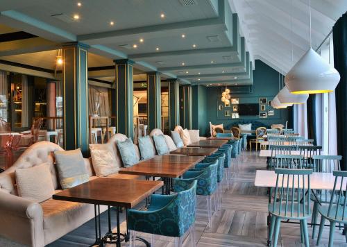 开普敦Peninsula All Suite Hotel by Dream Resorts的一间在房间内配有桌椅的餐厅