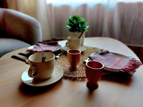 马尔梅迪MyDeer - Deluxe rooms & shared kitchen的一张桌子,上面放咖啡杯和餐巾