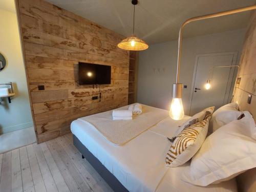 马尔梅迪MyDeer - Deluxe rooms & shared kitchen的卧室配有一张白色大床和木墙