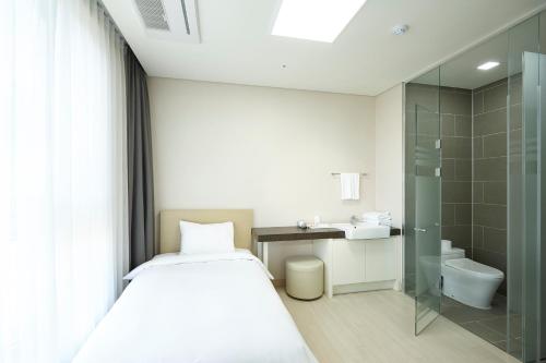 平昌Pyeongchang The White Hotel的小型浴室设有一张床和淋浴。