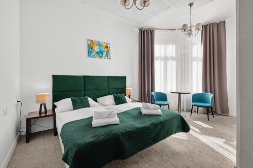 布拉迪斯拉发伊丽莎白旧城旅馆的一间卧室配有一张绿色大床和蓝色椅子