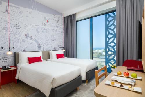 马斯喀特IntercityHotel Muscat的酒店客房设有两张床和一张桌子。