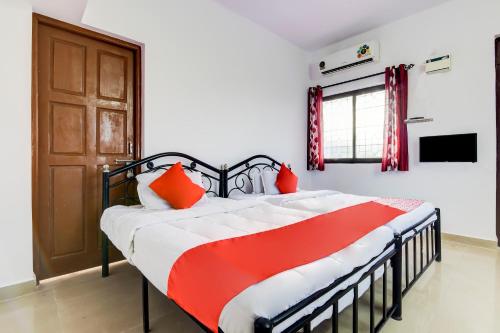 帕纳吉OYO Flagship Omkar Guest House Near Immaculate Conception Church的一间卧室配有一张带橙色枕头的大床