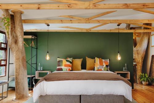 穆德斯蒂夫Elsewhere Treehouse and Apartment on the River的一间卧室设有一张大床和绿色的墙壁