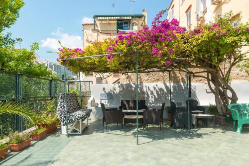 伊斯基亚Villa dei Sogni - Aparthotel Ischia Ponte的庭院配有桌椅和鲜花