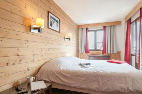 阿沃里亚兹萨斯基亚法莱斯皮埃尔假日酒店的一间卧室设有一张床和木墙