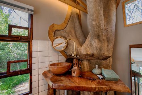 穆德斯蒂夫Elsewhere Treehouse and Apartment on the River的一间带木制水槽和镜子的浴室