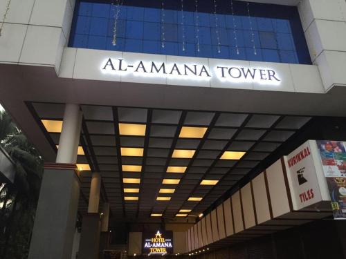 KondottiHOTEL AL AMANA TOWER的一座有标志的建筑,上面有读到阿玛玛娜塔的标志